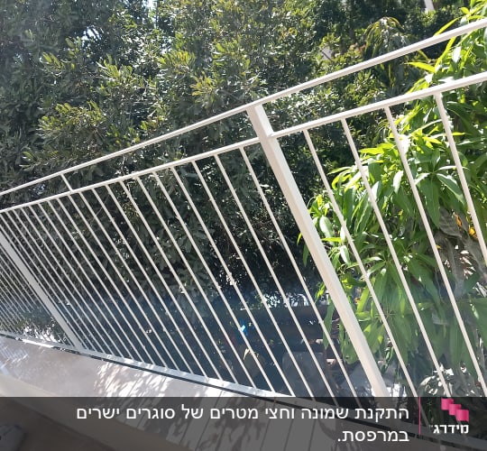 מעקה ממתכת בצבע לבן מותקן במרפסת מול נוף ירוק
